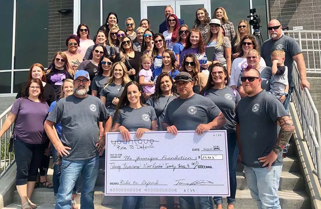 Group of volunteers with Ride for Defend presenting a check to the Younique Foundation