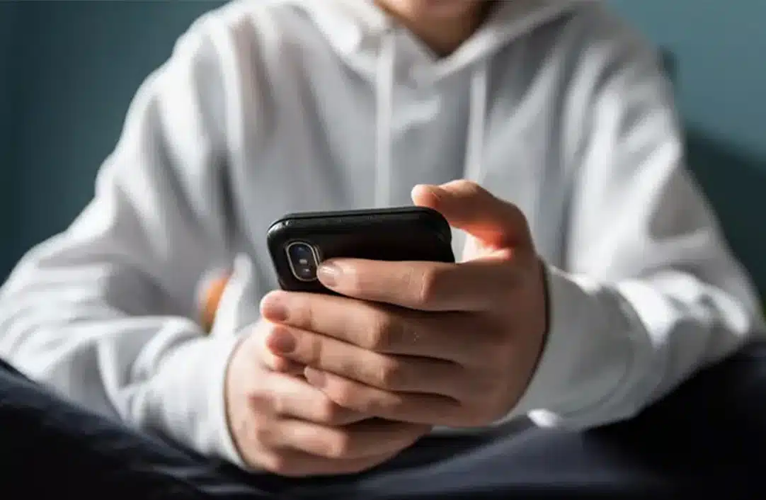 Teen boys holding a cell phone in his hands