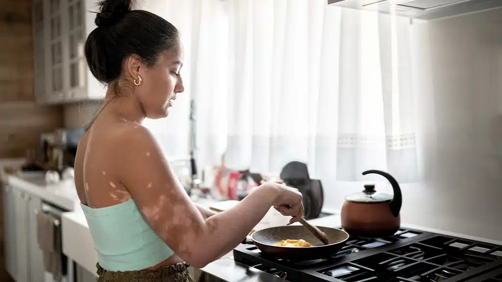 Latina woman standing beside stove cooking