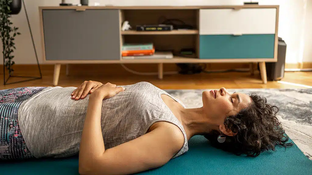 Woman laying on floor focusing on her breathing